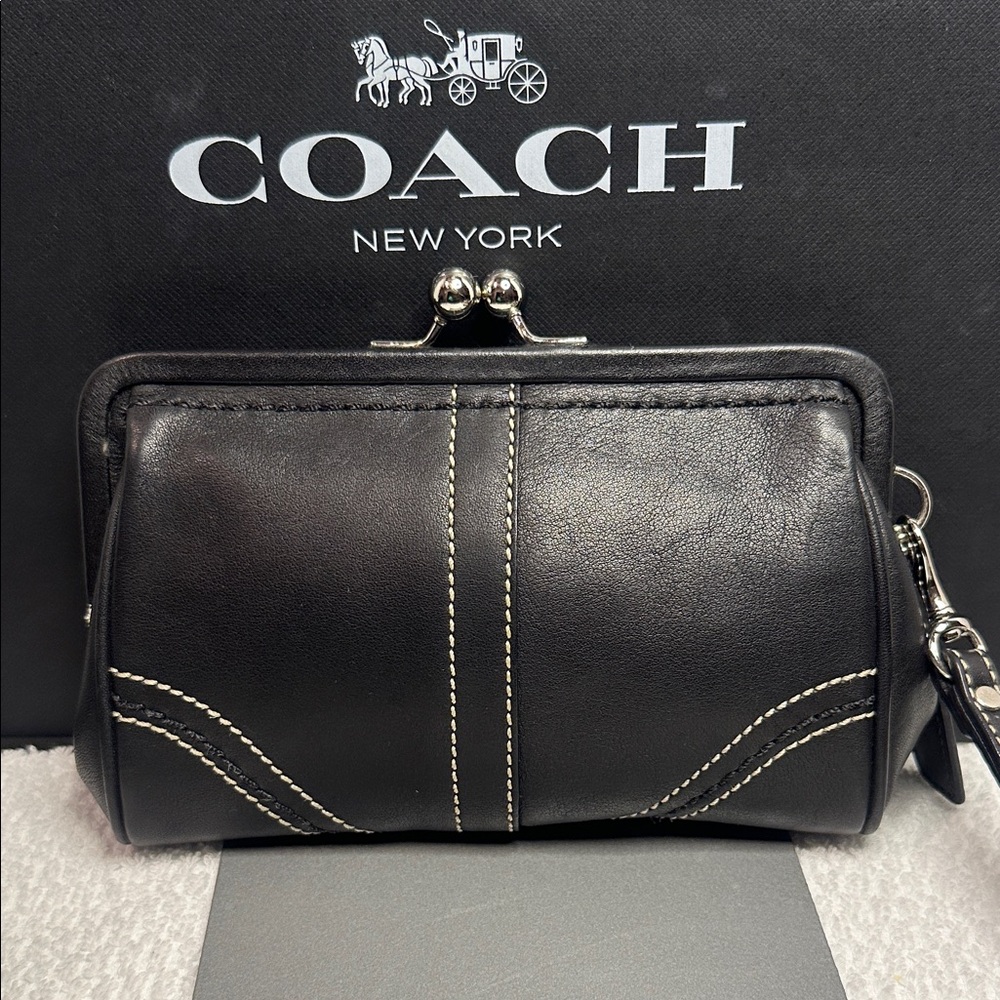 Coach kisslock Black Leather wristlet with White Stitching.